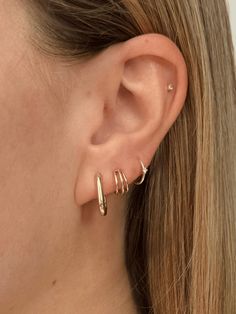 Elevate your earring game with our Triple Hoop Huggie Earrings, crafted from 14k gold. Featuring three sleek hoops seamlessly soldered together, these huggies offer a modern twist on a classic look. Designed to hug your earlobe with a secure butterfly back and post, they’re perfect for adding a touch of bold elegance to any outfit, from everyday wear to special occasions. 1st And 2nd Ear Piercings, Minimalist Earring Stack, 3 Earrings Piercing Ideas, 2 Ear Piercings, Triple Lobe Piercing, Second Piercings, Three Ear Piercings, Minimalist Ear Piercings, Tennis Jewelry