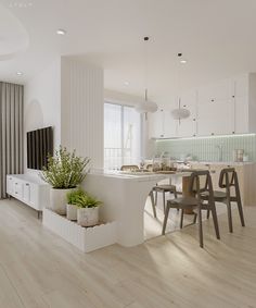 an open kitchen and dining area with white walls, wood flooring and large windows