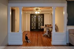 an empty room with wood floors and white trim on the walls, along with a black door