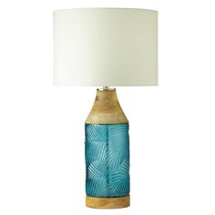 a blue glass lamp with a white shade on the base and a gold metal base