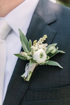 a man in a suit and tie wearing a boutonniere