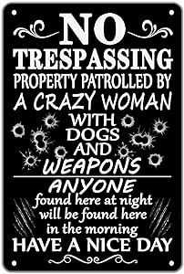 a sign that says no trespassing property patroled by a crazy woman