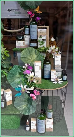 a display in a store filled with lots of bottles and flowers next to each other