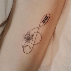 a tattoo on the leg of a person with a piano keyboard and flower in it