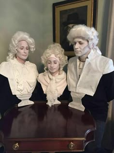 three people dressed in white wigs standing next to a piano