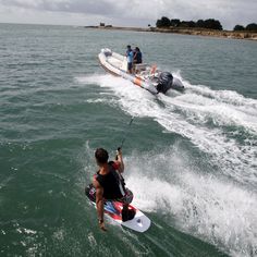 a man riding on the back of a jet ski while being pulled by a boat