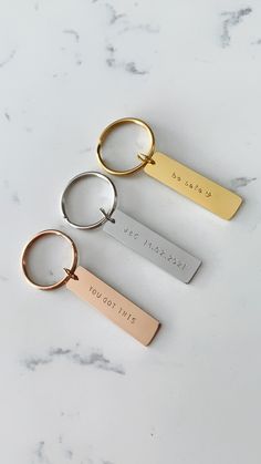 three personalized keychains on a marble surface