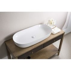 a white sink sitting on top of a wooden table