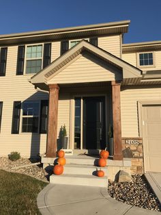 a house with pumpkins on the front steps