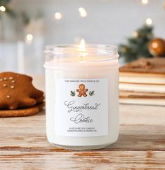 a candle is sitting on a table next to some cookies and a cookie in the shape of a gingerbread