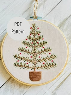 a hand embroidered christmas tree in a pot on a white wooden background with text overlay that reads, pdf pattern