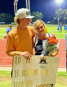 two people standing next to each other holding flowers and a sign that says it's someone else took you hoo?