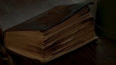 an old book sitting on top of a wooden table