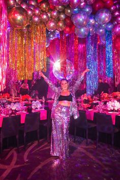 a woman standing in front of balloons and tables