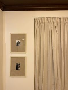 three framed pictures hang on the wall next to a curtain