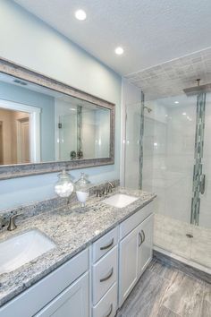 a large bathroom with two sinks and a walk - in shower next to the tub