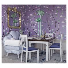 a dining room with purple wallpaper and white chairs