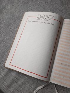 an open notebook with the words dnf on it sitting on top of a bed