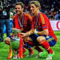 two soccer players pose for a photo with the trophy