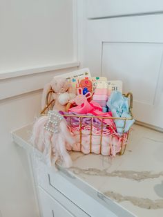 a basket filled with lots of baby items on top of a white counter next to a door