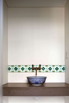 a bathroom sink sitting under a faucet next to a wall