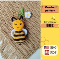 a crocheted keychain with a bee on it and flowers in the background