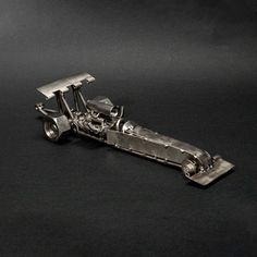 a metal model of a race car on a black background