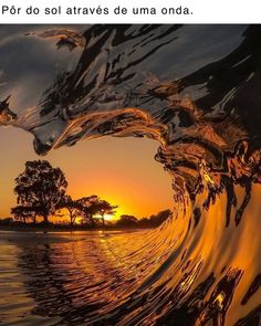 the sun is setting behind an ocean wave