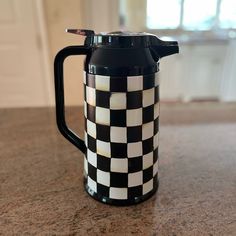 a black and white checkered coffee pot on a counter