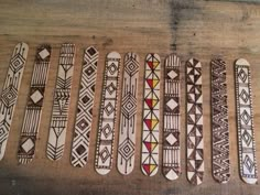 six skateboards are lined up on a wooden surface with different designs painted on them