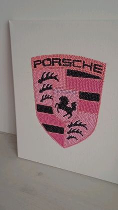 a pink and black embroidered emblem on a white canvas