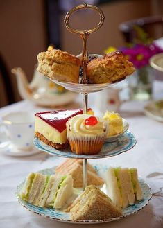 three tiered trays filled with different types of desserts on top of a table