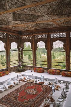 a room filled with lots of windows covered in decorative furniture and decorating items on top of a rug