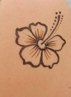 a woman's back with a flower tattoo on it