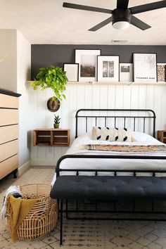 a bedroom with a bed, dresser and pictures on the wall