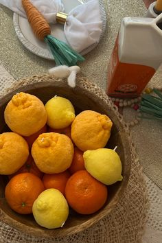 a bowl filled with oranges and lemons on top of a cloth covered table