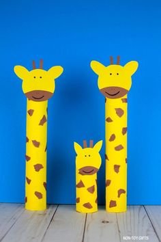 two giraffes are standing next to each other in front of a blue wall