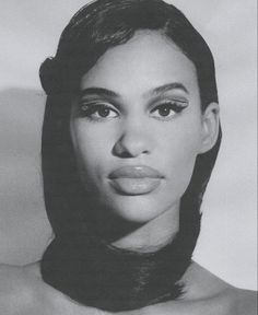 a black and white photo of a woman's face with her hair pulled back