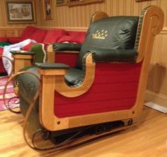 a wooden rocking chair sitting on top of a hard wood floor next to a red couch