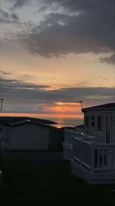 the sun is setting behind some houses