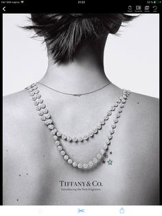 a black and white photo of a woman's back with jewelry on her neck