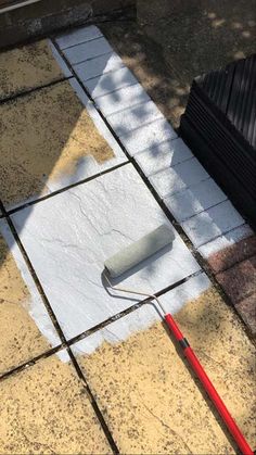 a painting roller laying on the ground next to a building