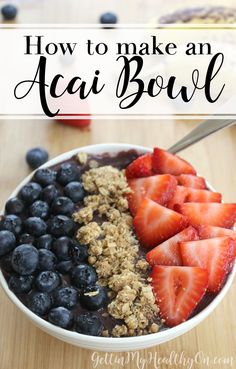 a bowl filled with fruit and granola on top of a wooden table