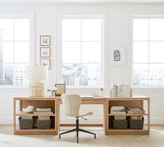 an office with two desks and chairs in front of large windows overlooking the city