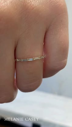 A woman's hand wearing a dainty diamond band. Mixed Metal Band Ring, Stone Band Rings, Hidden Diamond Wedding Band, Simple Birthstone Rings, Eternity Ring Diamond Stack Engagement, Wedding Band Dainty, White Gold And Yellow Gold Wedding Set, Spacer Band Ring, Aquamarine Jewelry Rings