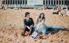 a man and woman sitting on the beach next to each other