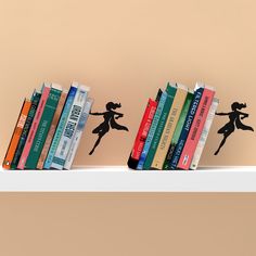 a row of books sitting on top of a white shelf next to a brown wall