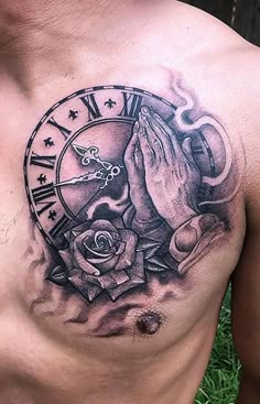 a man with a tattoo on his chest holding hands in front of a clock and roses