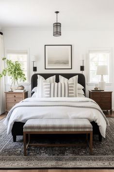 a bed with white sheets and pillows in a bedroom