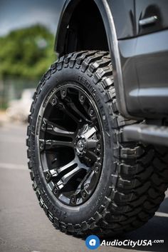 the front wheel and tire of a black truck